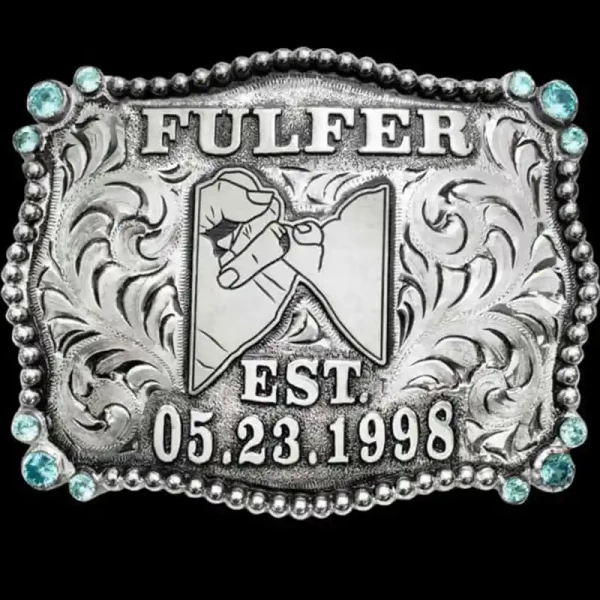 "Our Lovington Belt Buckle is built to tell a story. Hand-engraved on a German Silver base, this stunning buckle features a beaded edge, three cubic zirconia stones in each corner—with the option to choose your preferred color—and German Silver lette